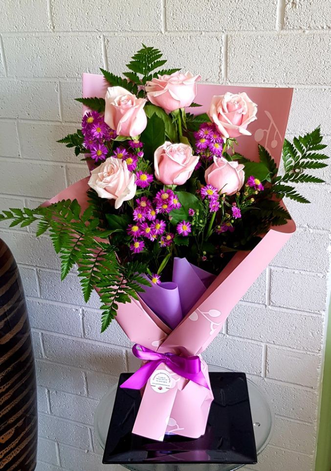 A Bouquet of Flowers Wrapped in White Paper With a Pink Ribbon โ Greenfield Blooms and Gifts In Wanguri, NT