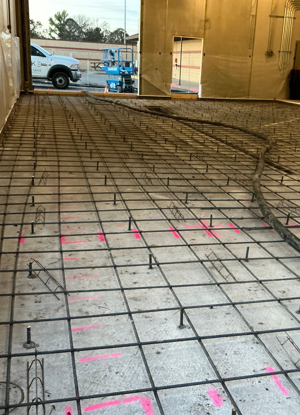 A concrete floor under construction with a truck parked in the background.