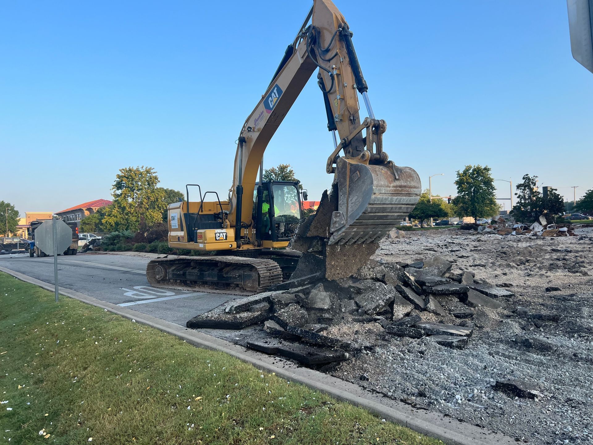 A large yellow excavator is working on a construction site.