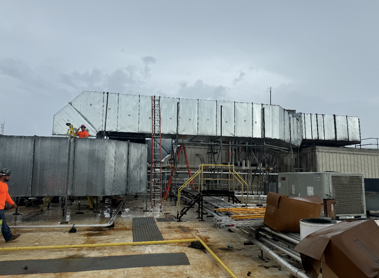 A group of construction workers are working on the roof of a building.