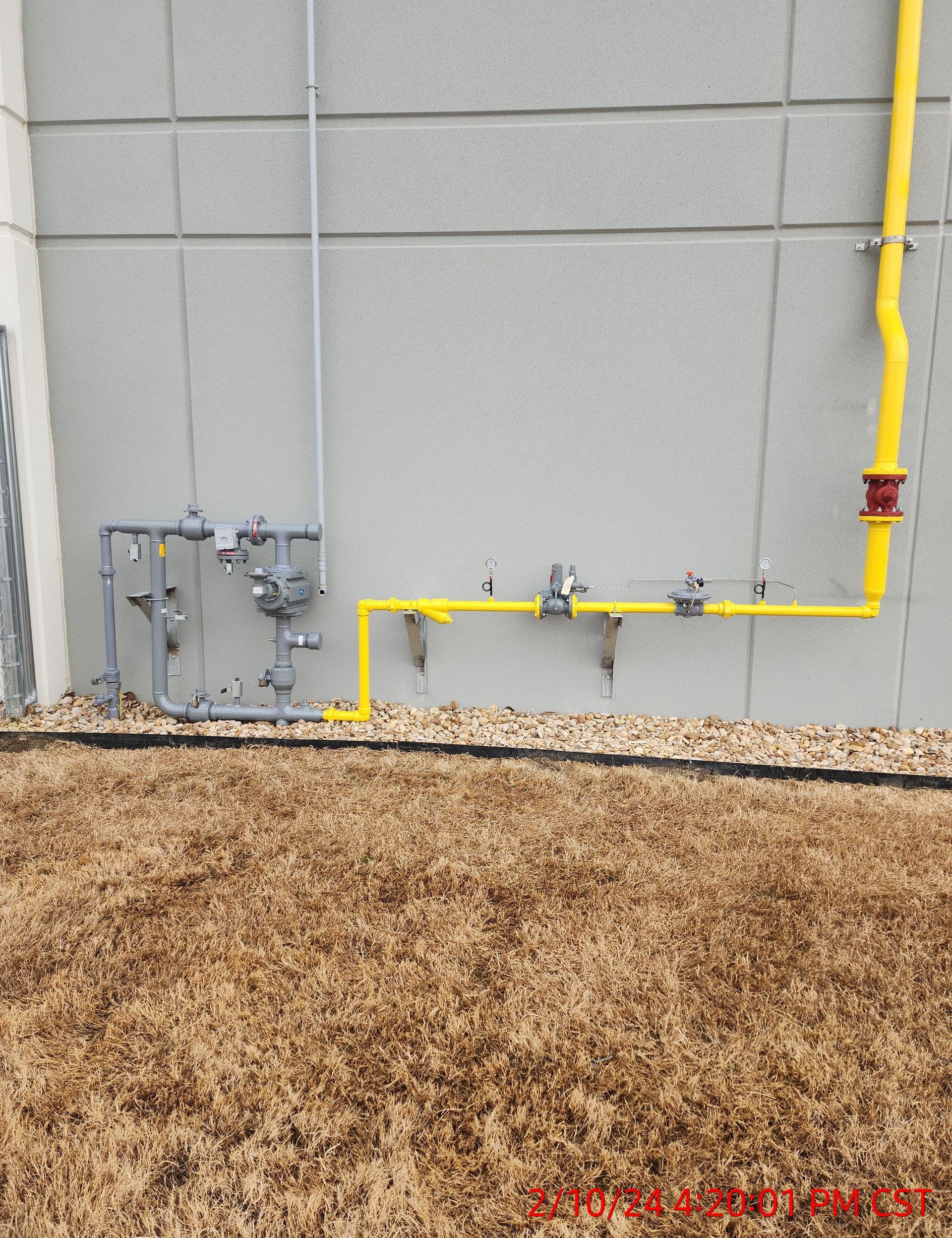 A yellow pipe is attached to the side of a building
