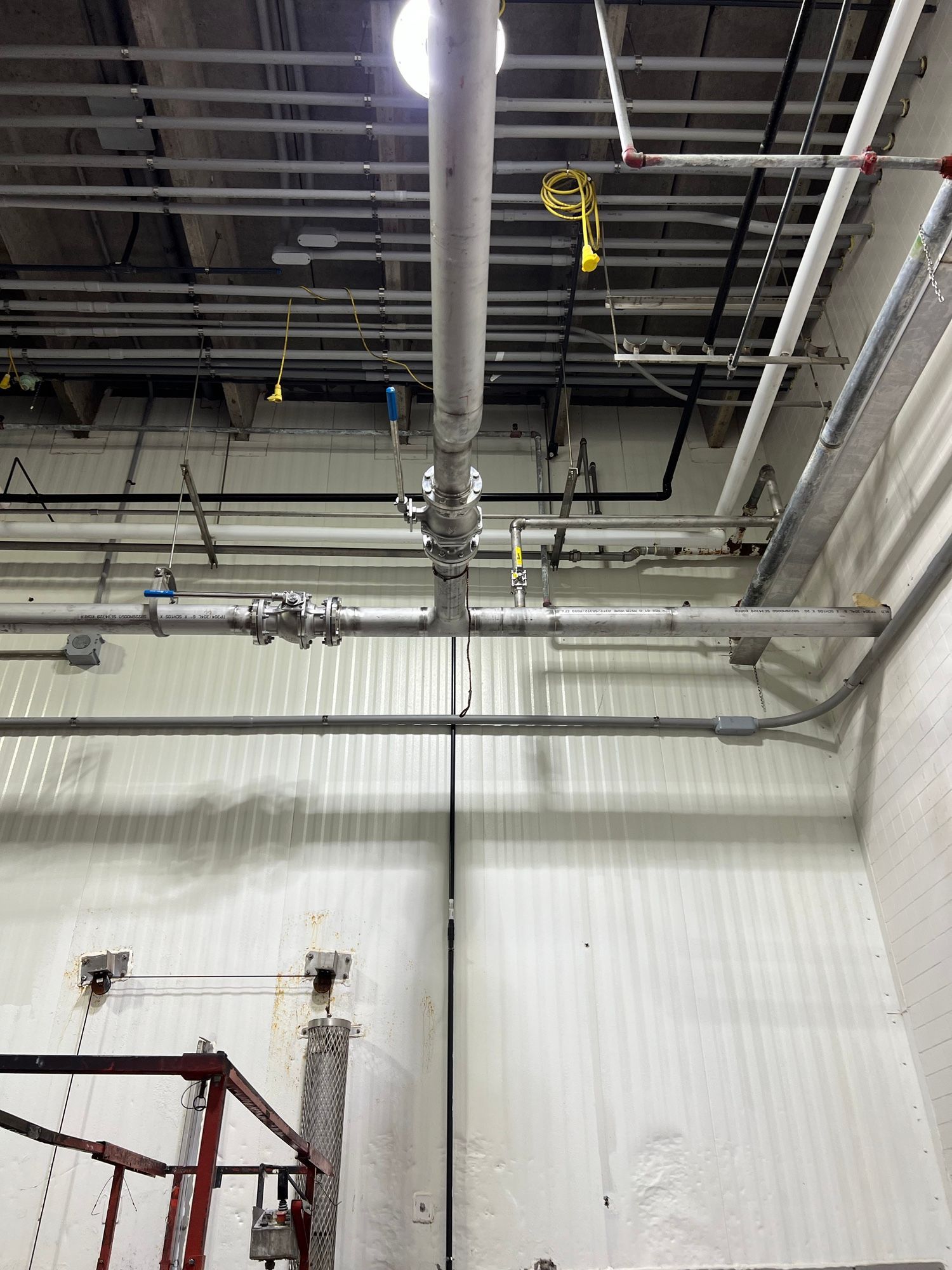 A room with a lot of pipes hanging from the ceiling.