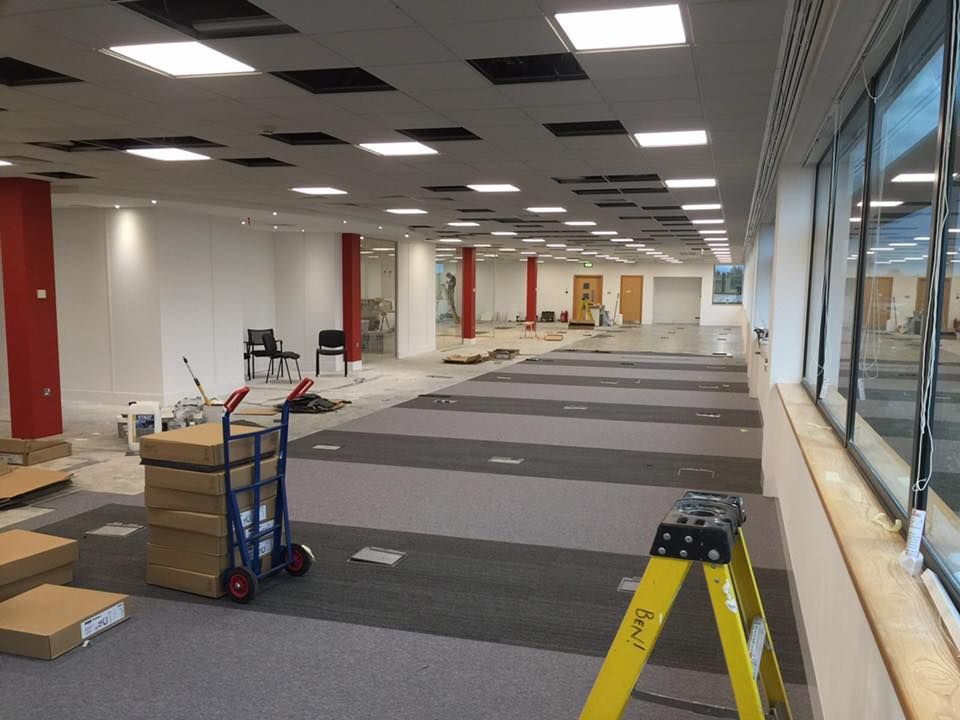 A large room with boxes on the floor and a yellow ladder