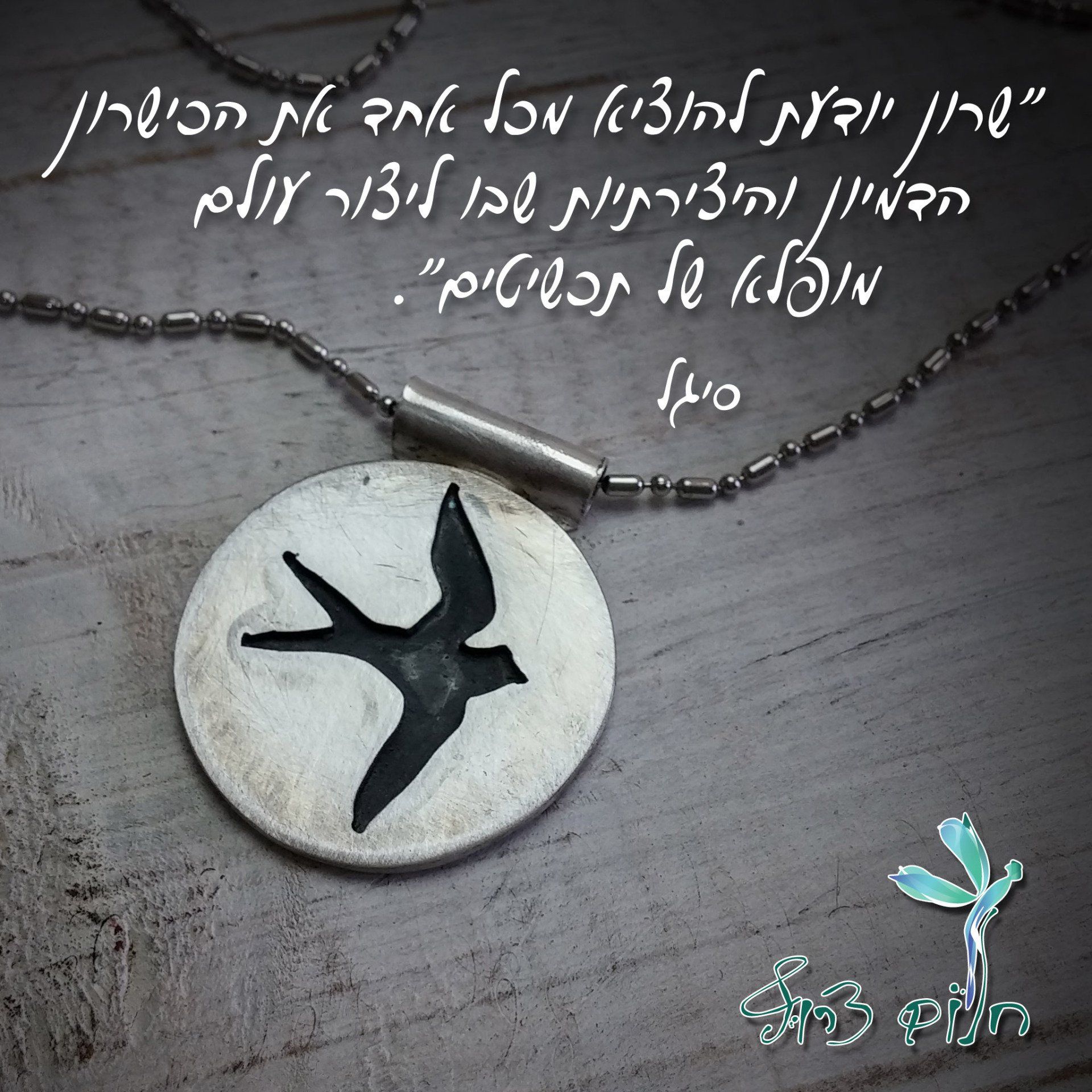 שרשרת עם ציפור עליה נמצאת על שולחן עץ