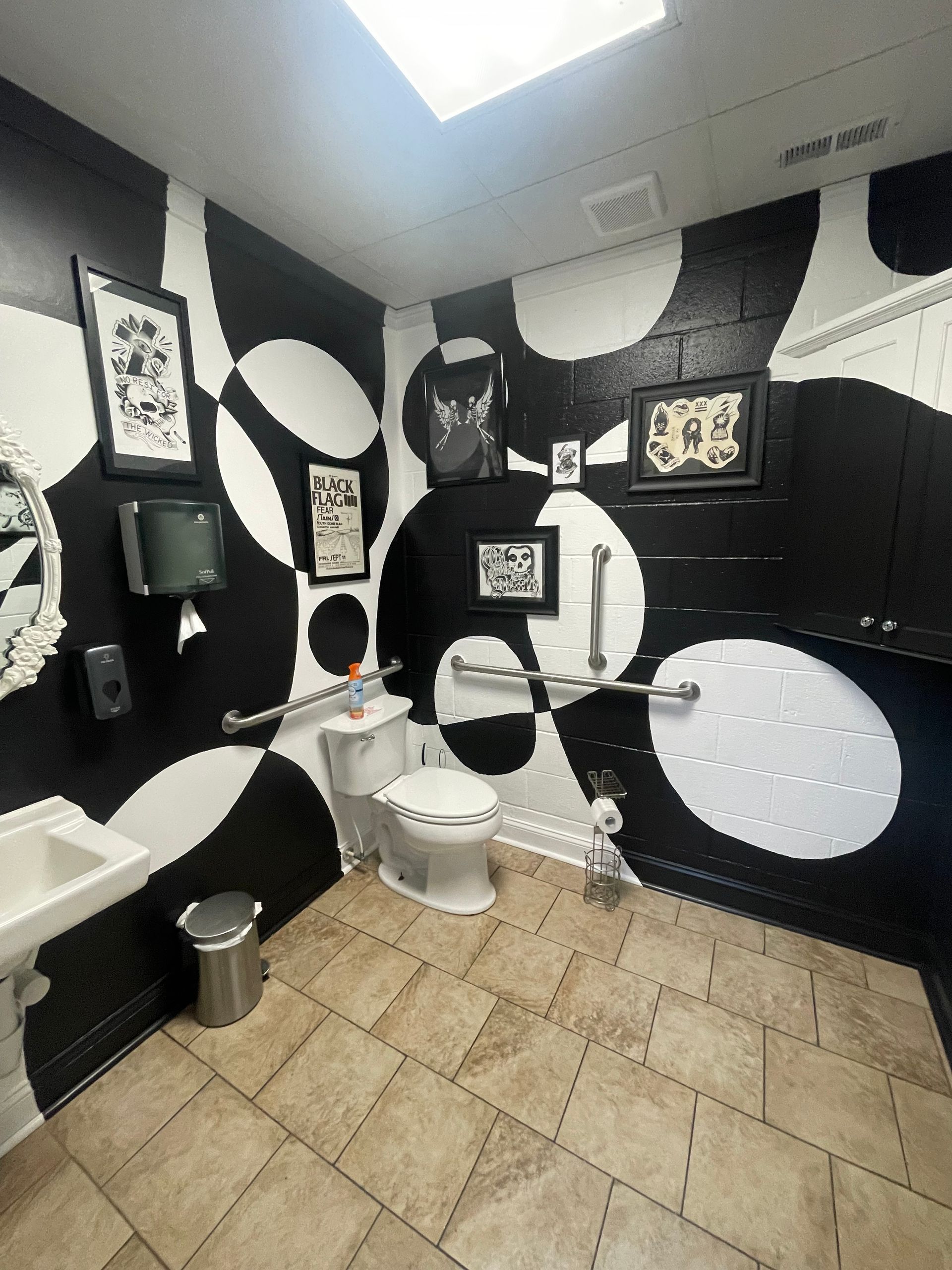 Black-and-white themed bathroom with a toilet, sink, and patterned tile floor.