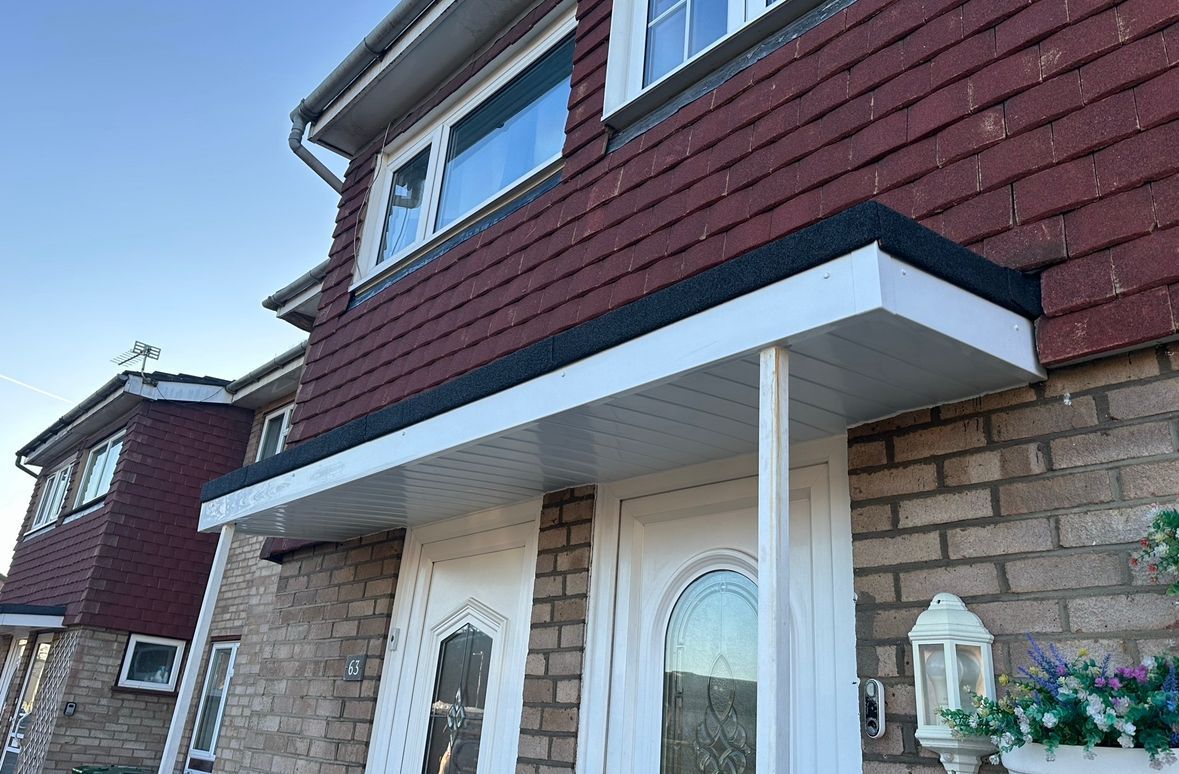 Front exterior of a house with a white canopy over the front door and brick siding.