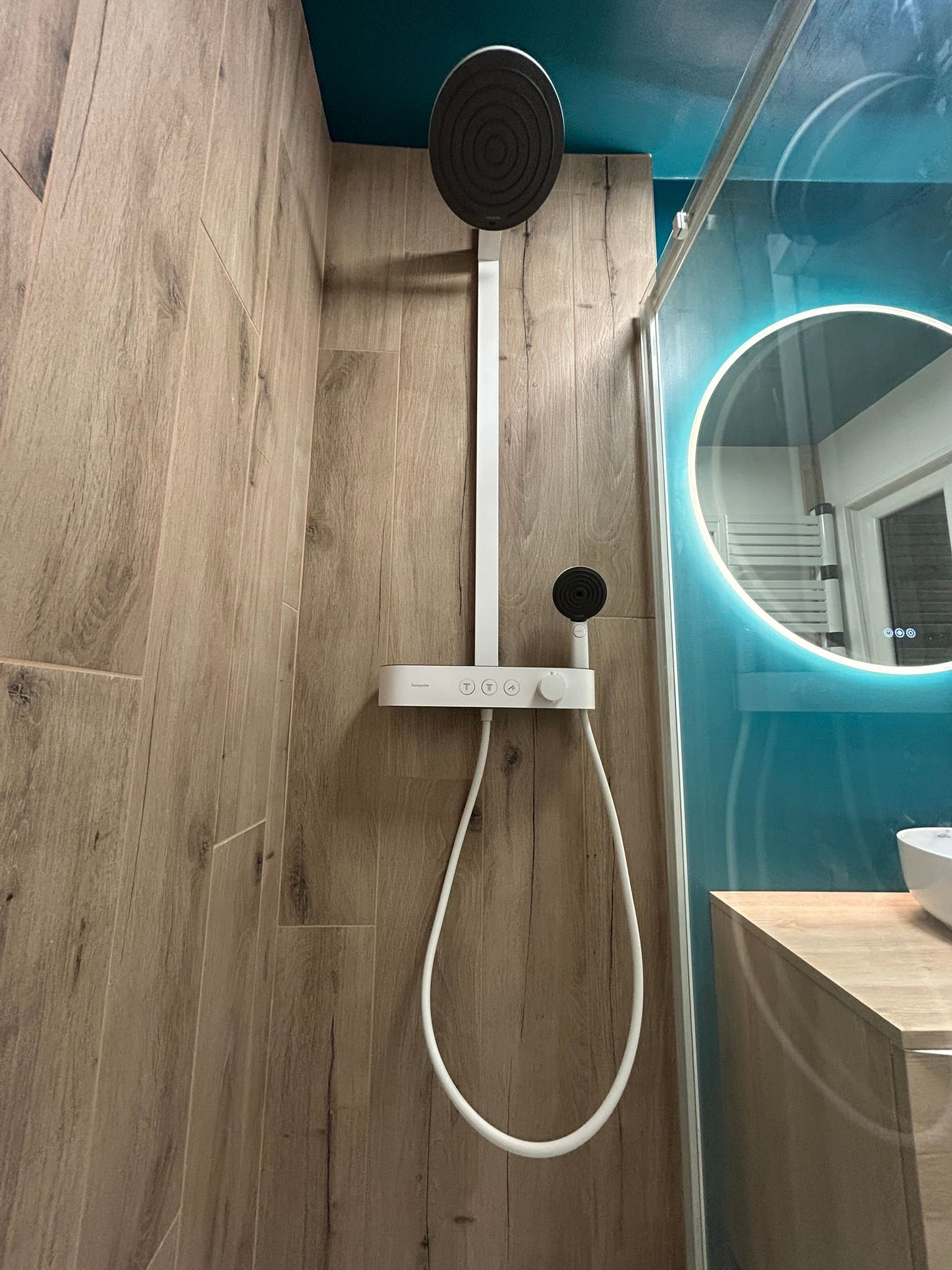 Douche à l'italienne avec lavabo et gros miroir rond