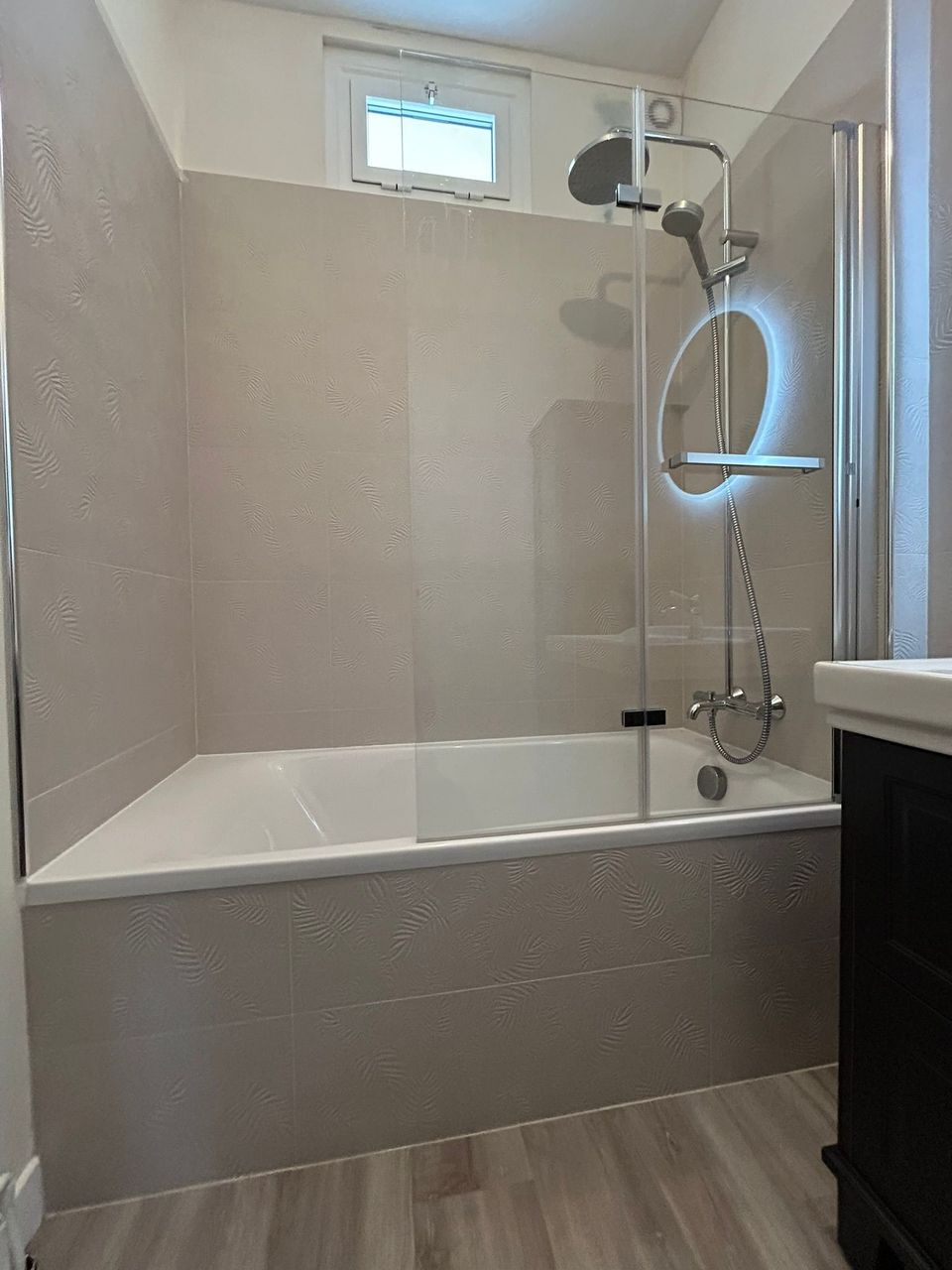 Baignoire avec pare-bain pivotant et colonne de douche, salle de bains rénovée au Havre