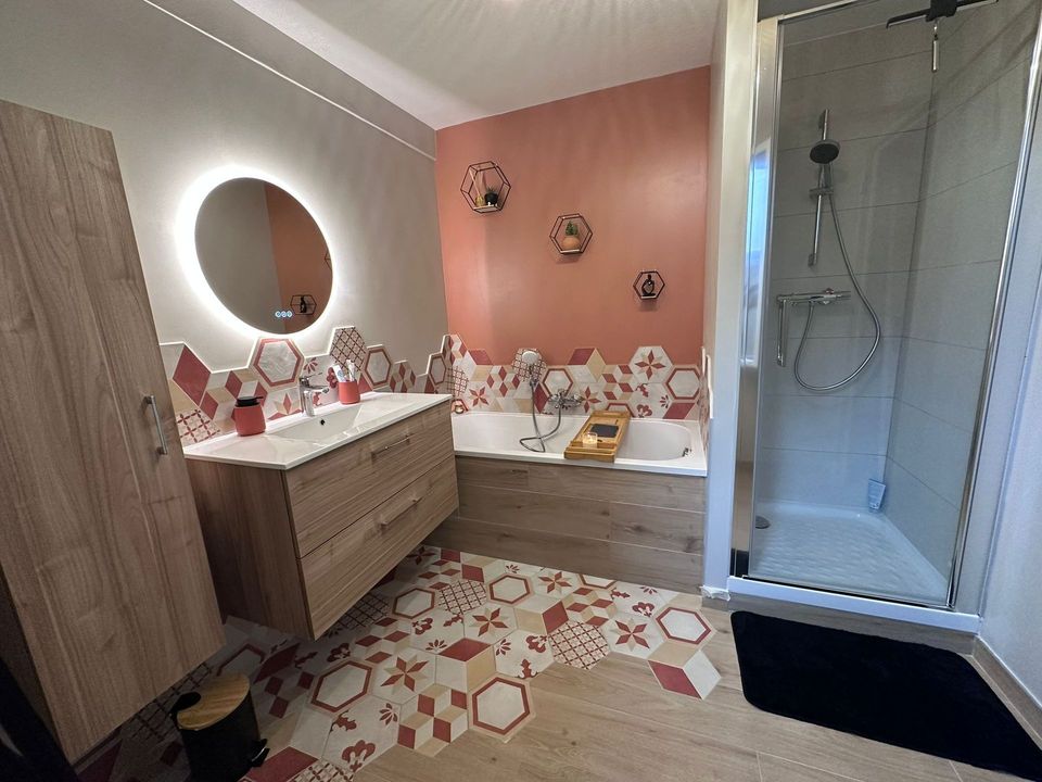 Salle de bain Paloma au Havre : meuble chêne, baignoire, douche et carreaux hexagonaux rouges et crème