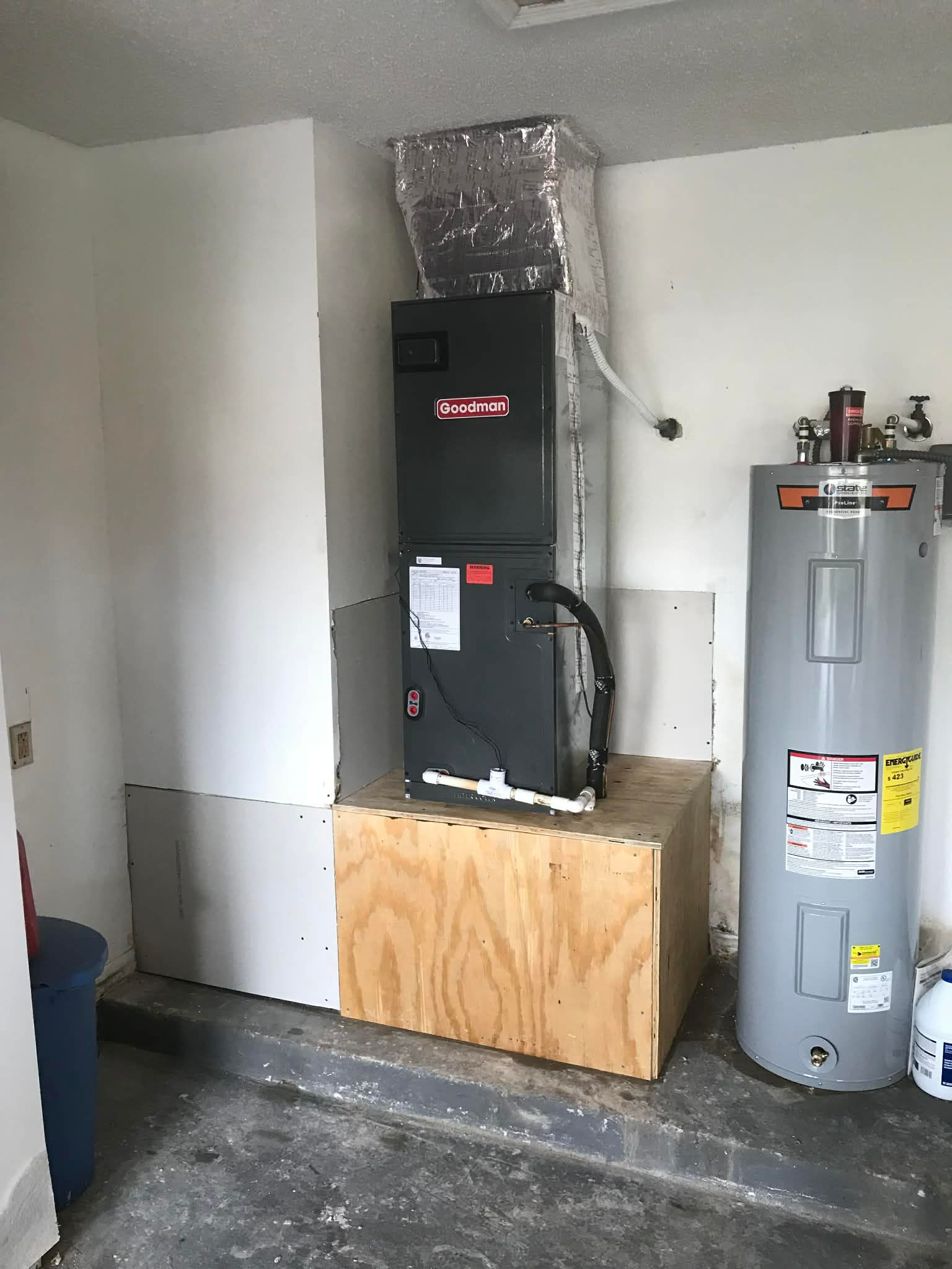 Outdoor air conditioner unit beside a house window on a brick patio