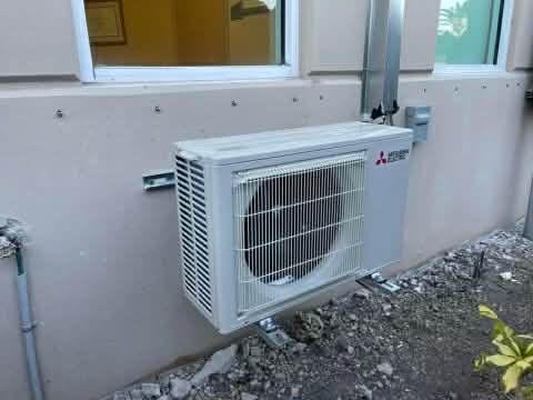 Rooftop HVAC units and metal ductwork packed tightly beside a rusted equipment enclosure.