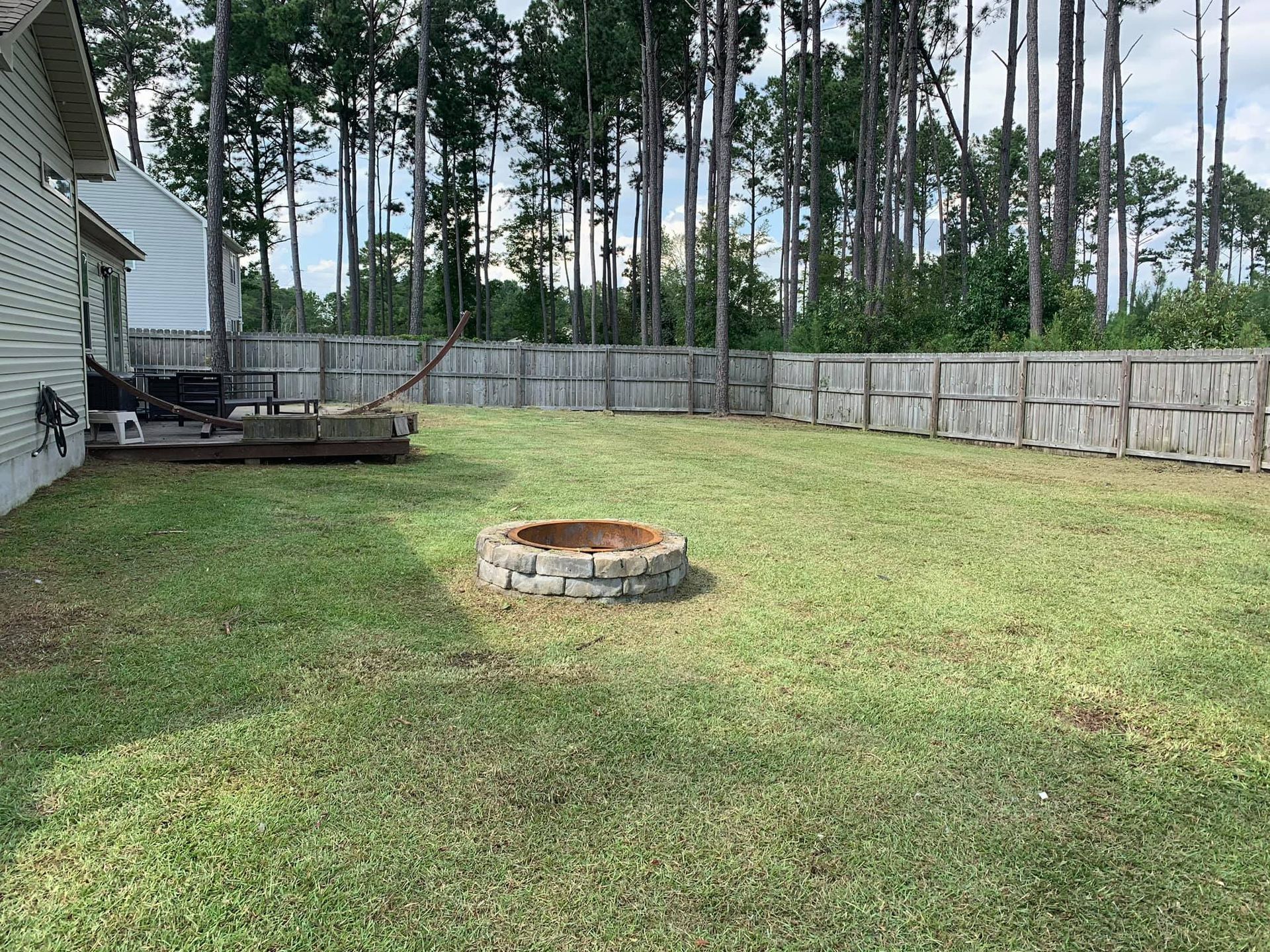There is a fire pit in the middle of the backyard.