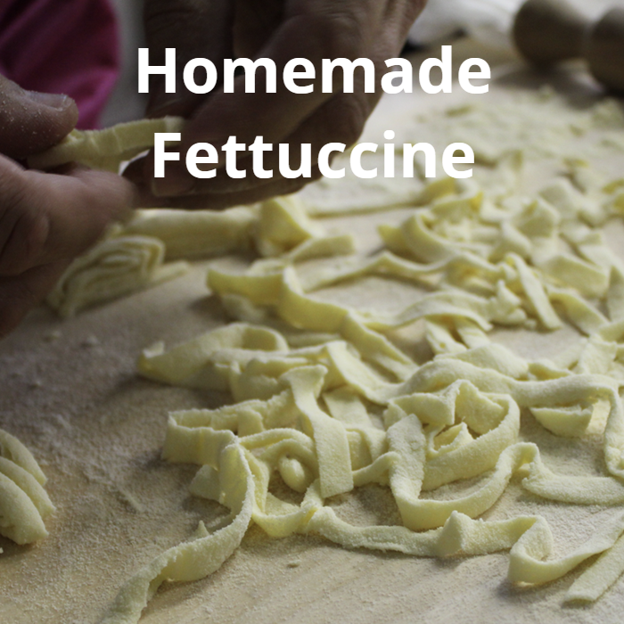 A plate of homemade fettuccine pasta made from 00 flour, eggs, and semolina, with thick ribbons of pasta cooked to perfection