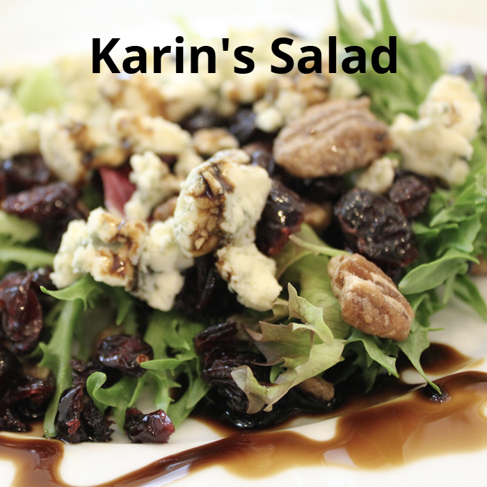 A fresh and vibrant Karin's Salad, featuring a mix of spring lettuce, glazed pecans, dried cranberries, crumbled bleu cheese, and drizzled with extra virgin olive oil and balsamic vinegar.