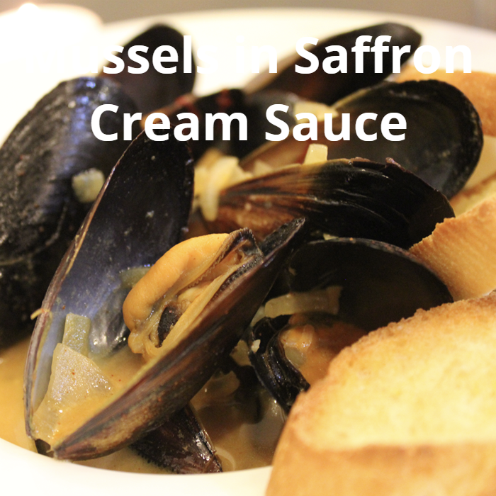A bowl of mussels in a rich cream sauce, garnished with chopped parsley and served alongside crispy crostini, ready to enjoy!