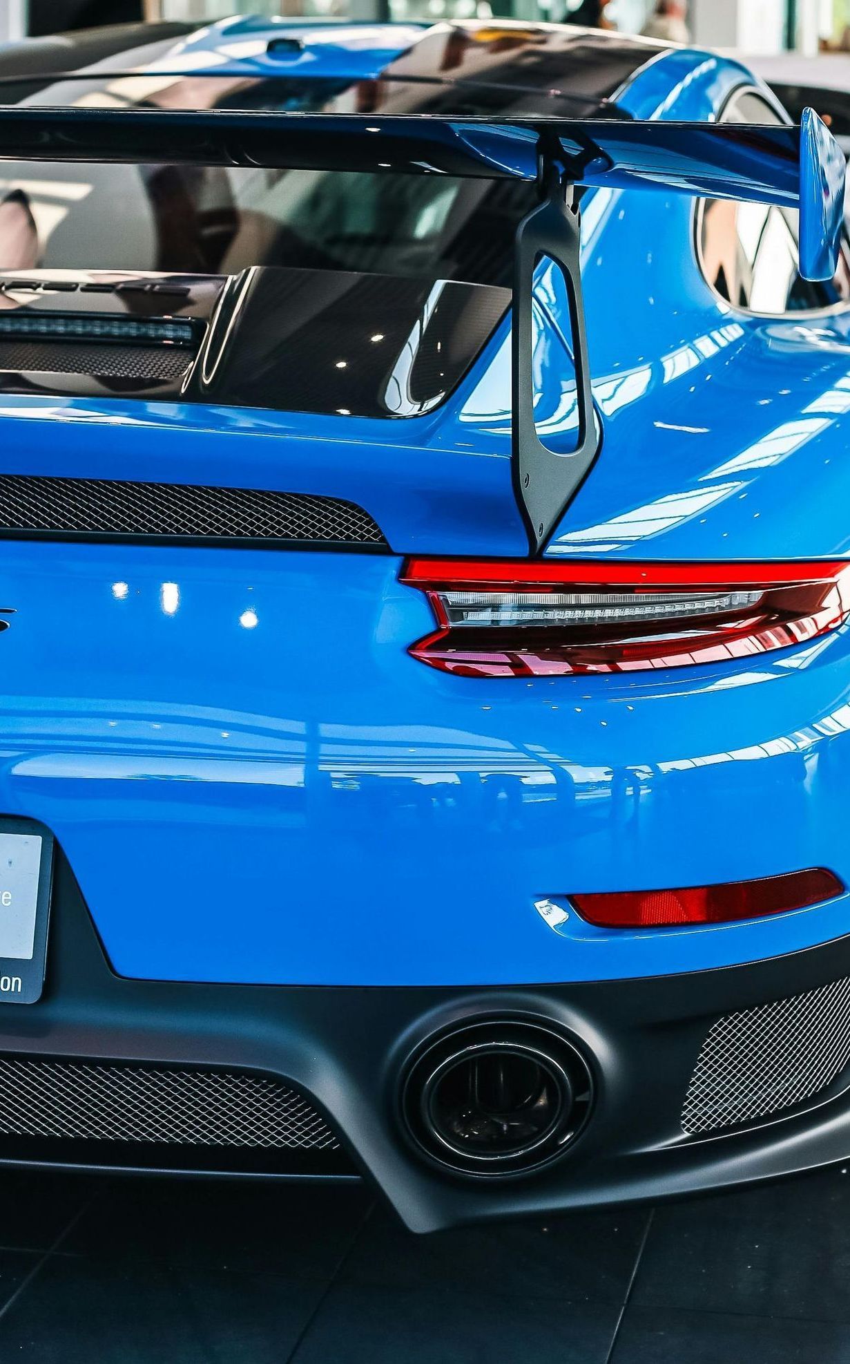 Blue Porsche 911 GT2 RS rear, showing taillights, spoiler, and exhaust.