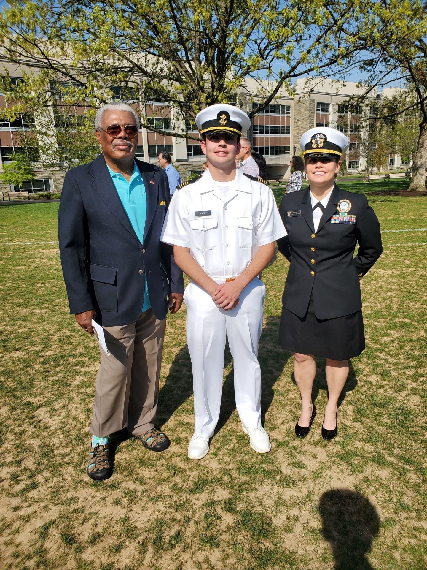 A group of people in military uniforms are posing for a picture in a park.