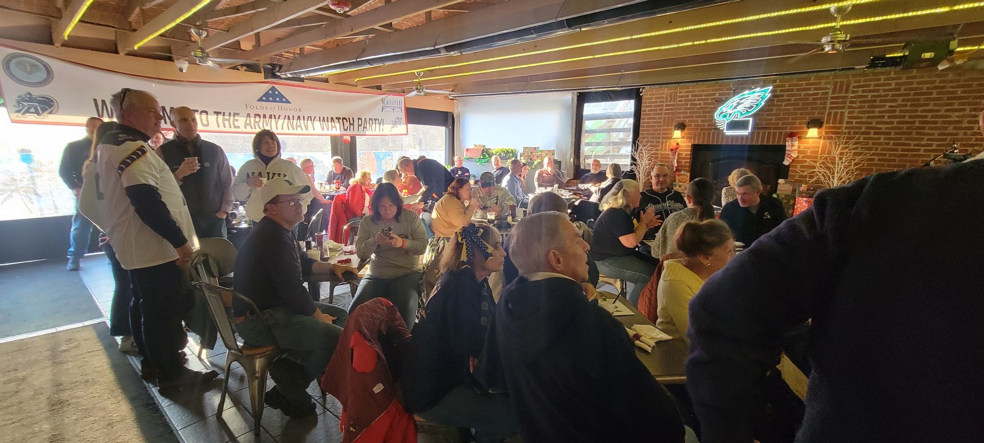 A large group of people are sitting at tables in a restaurant.