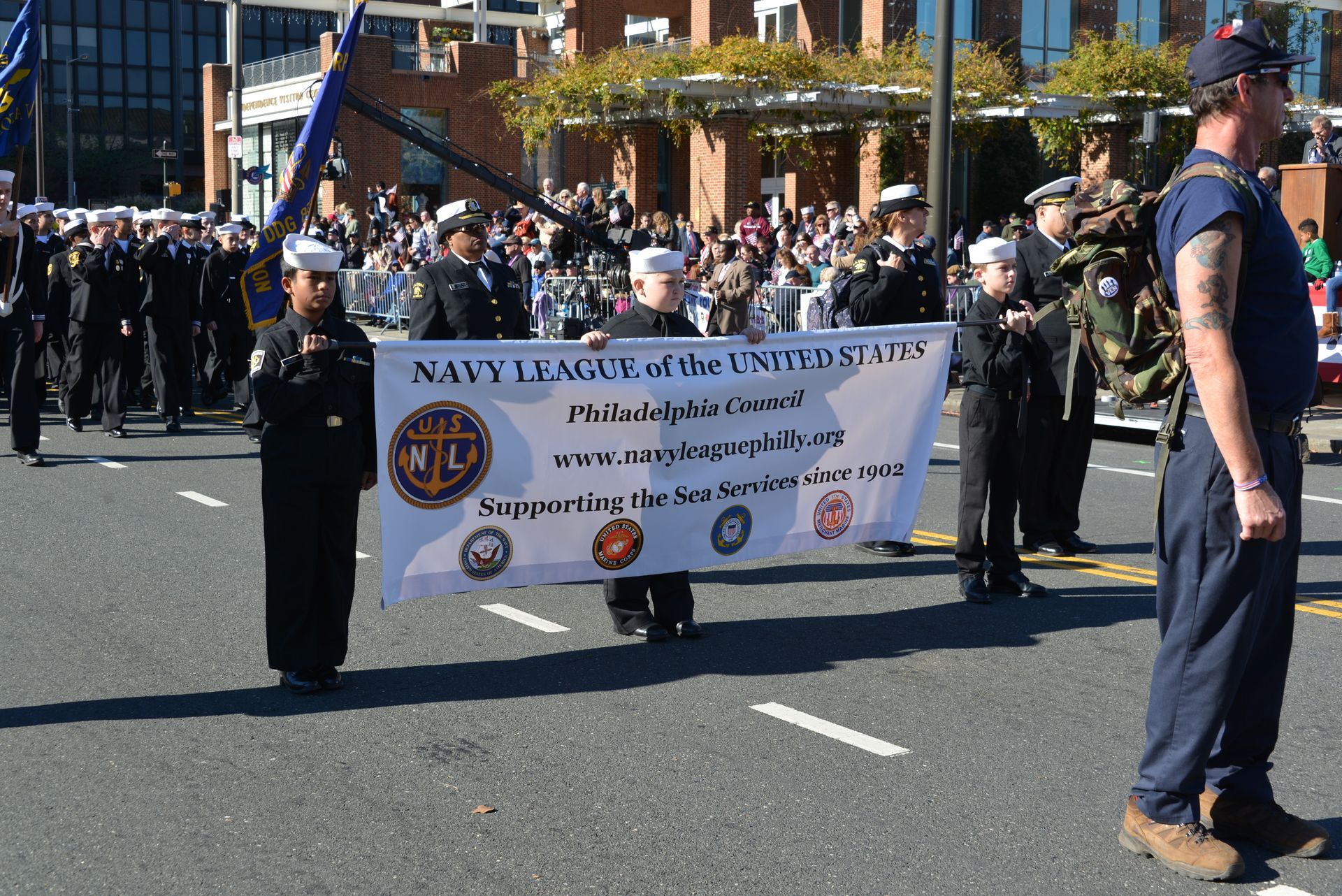 A man holding a sign that says navy legacy of the united states