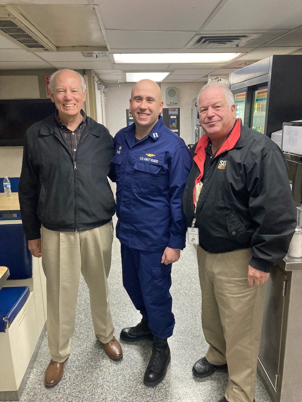 Three men are posing for a picture together in a room.