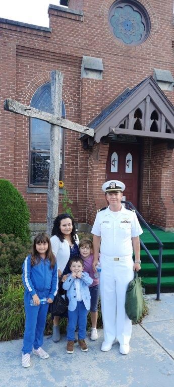 A group of people posing for a picture in front of a church.