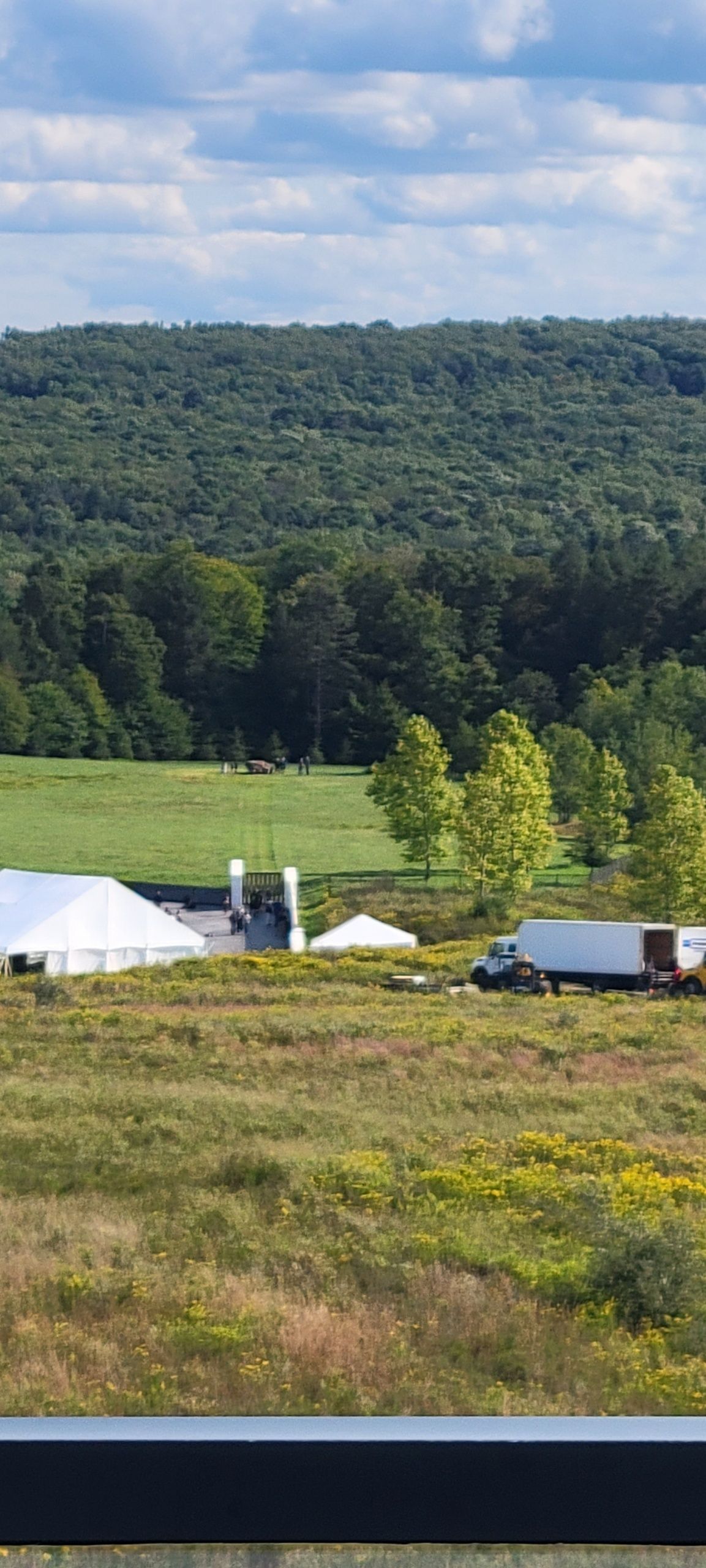 A Large White Tent Is Sitting in The Middle of A Grassy Field.