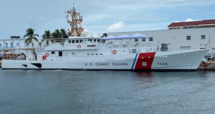 A large u.s. coast guard ship is docked in a harbor.