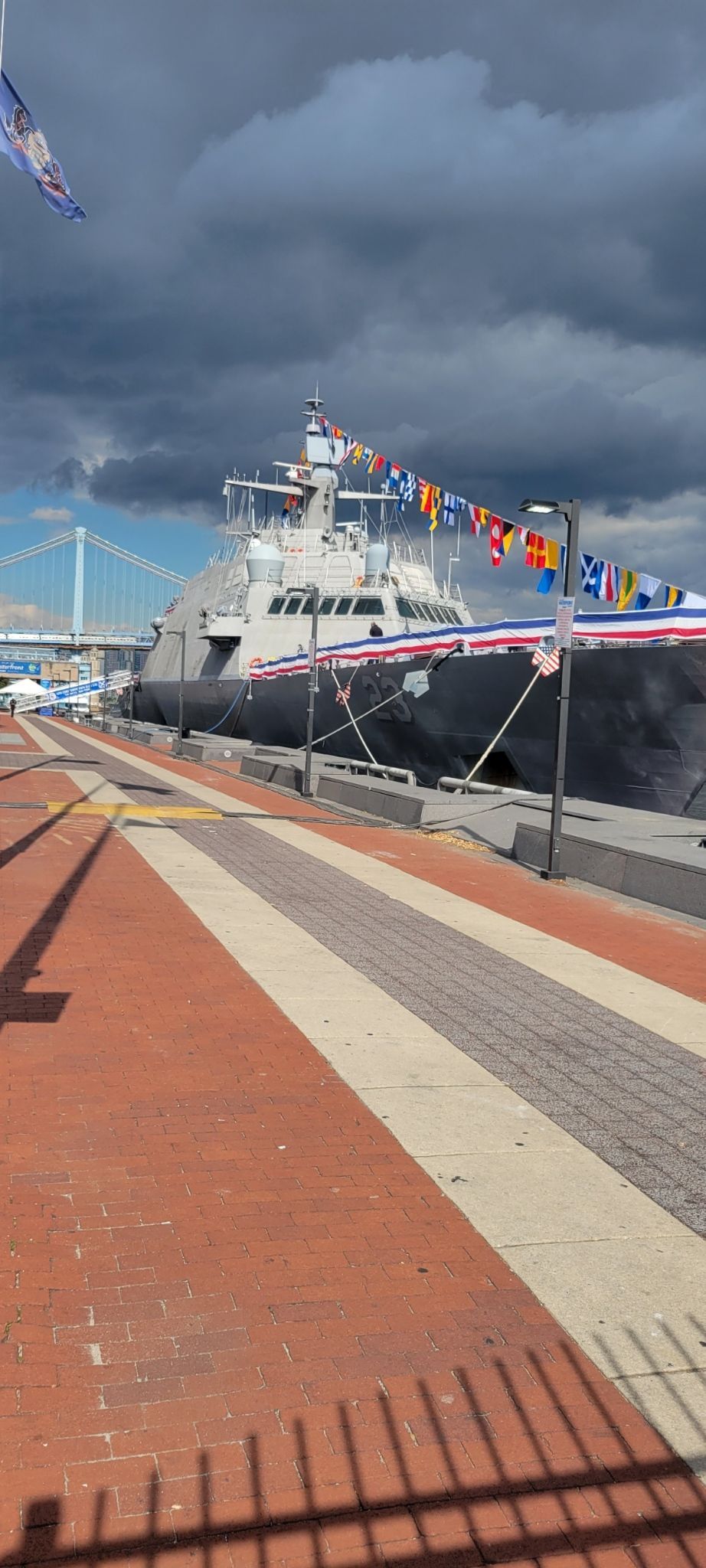 A large ship is docked in a harbor on a cloudy day