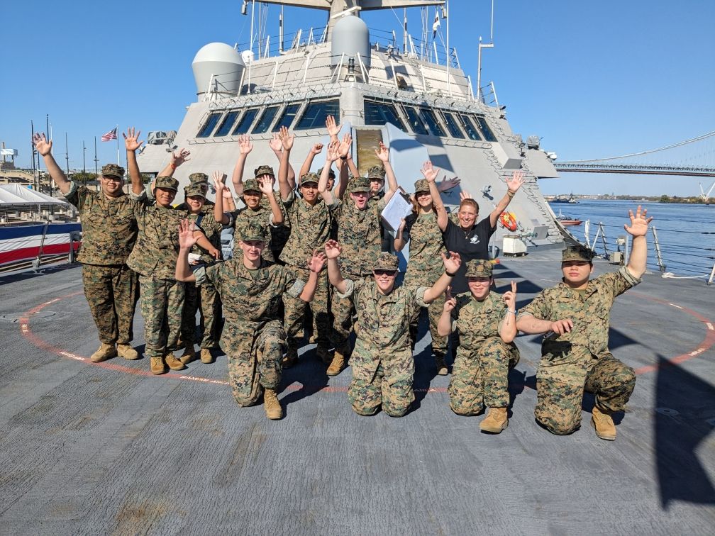 A group of soldiers are posing for a picture on the deck of a ship