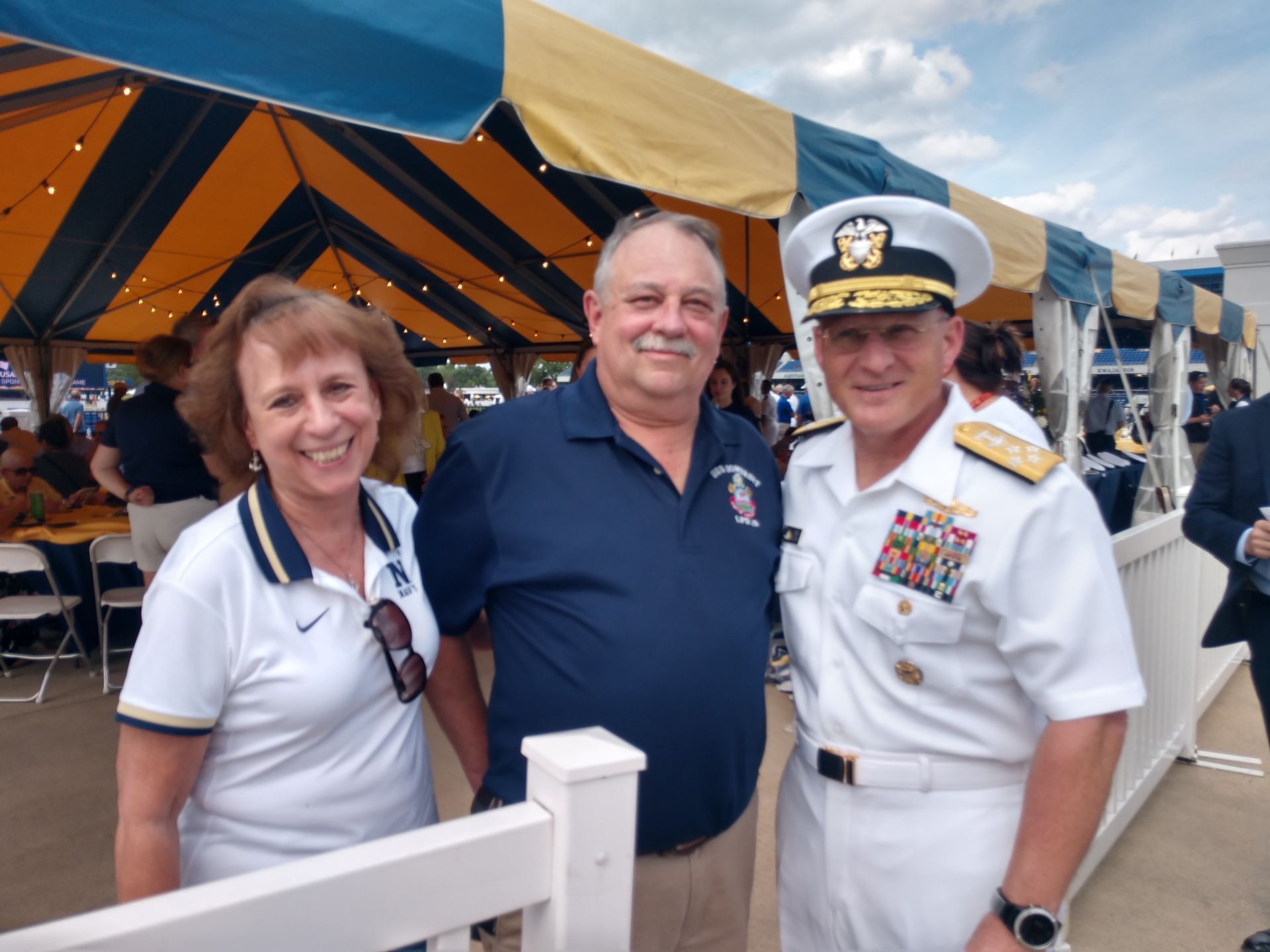 Three people posing for a picture in front of a tent