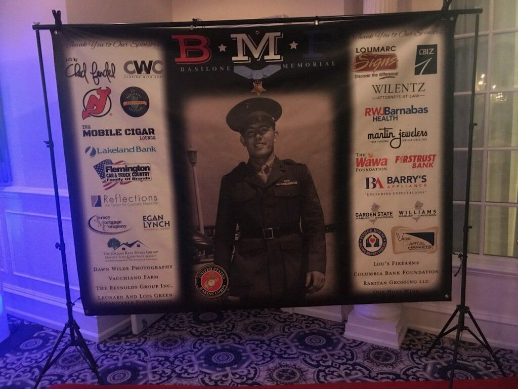 A man in a military uniform is standing in front of a banner that says bm