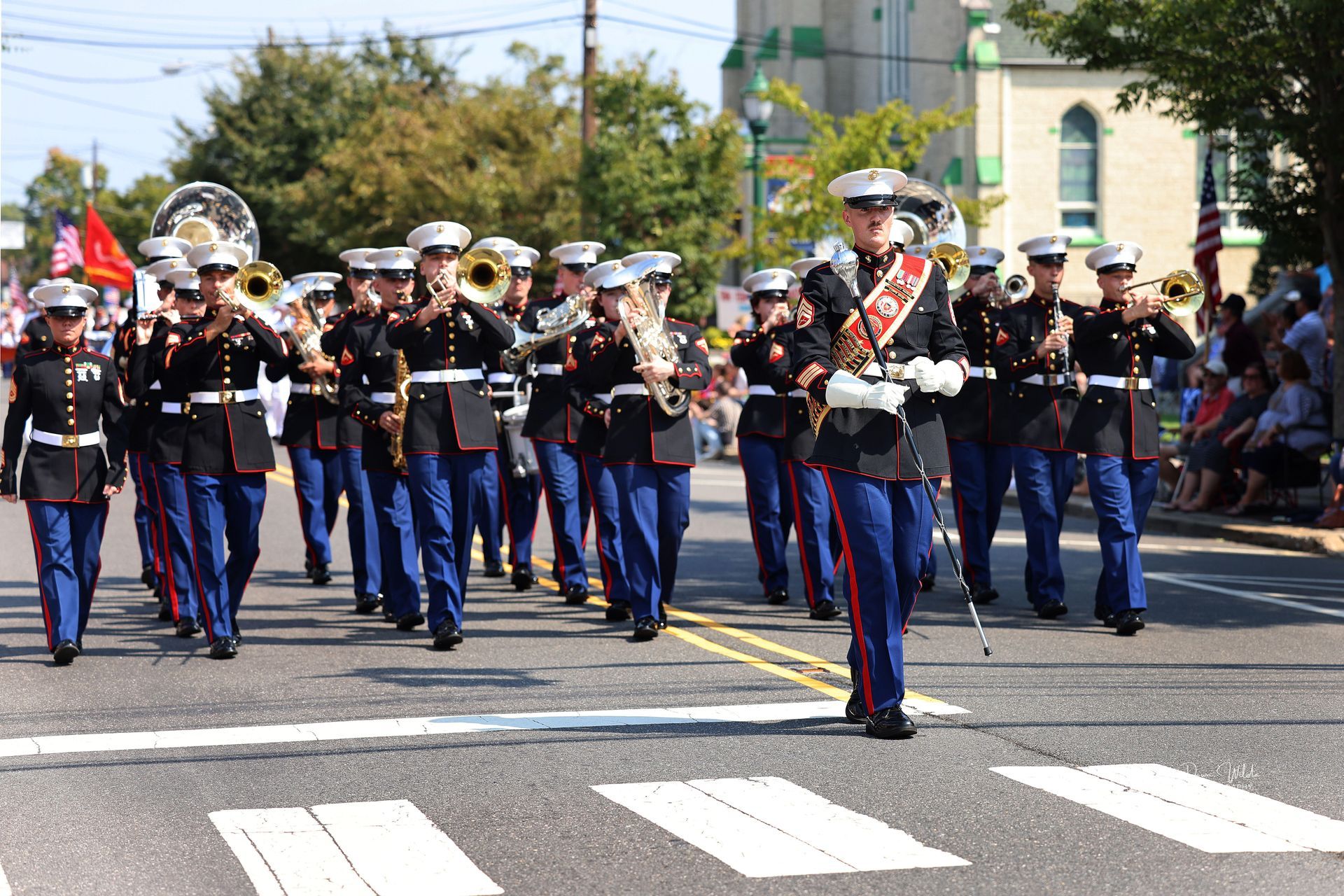 A marching band is marching down a street in a parade.