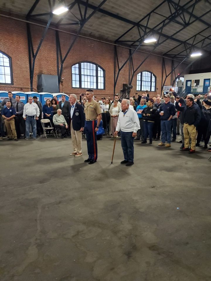A group of people are standing in a large room.