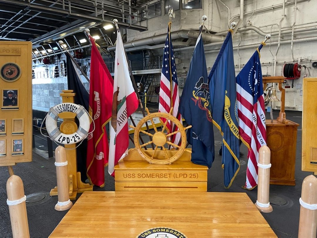 A wooden table with a steering wheel and flags on it.