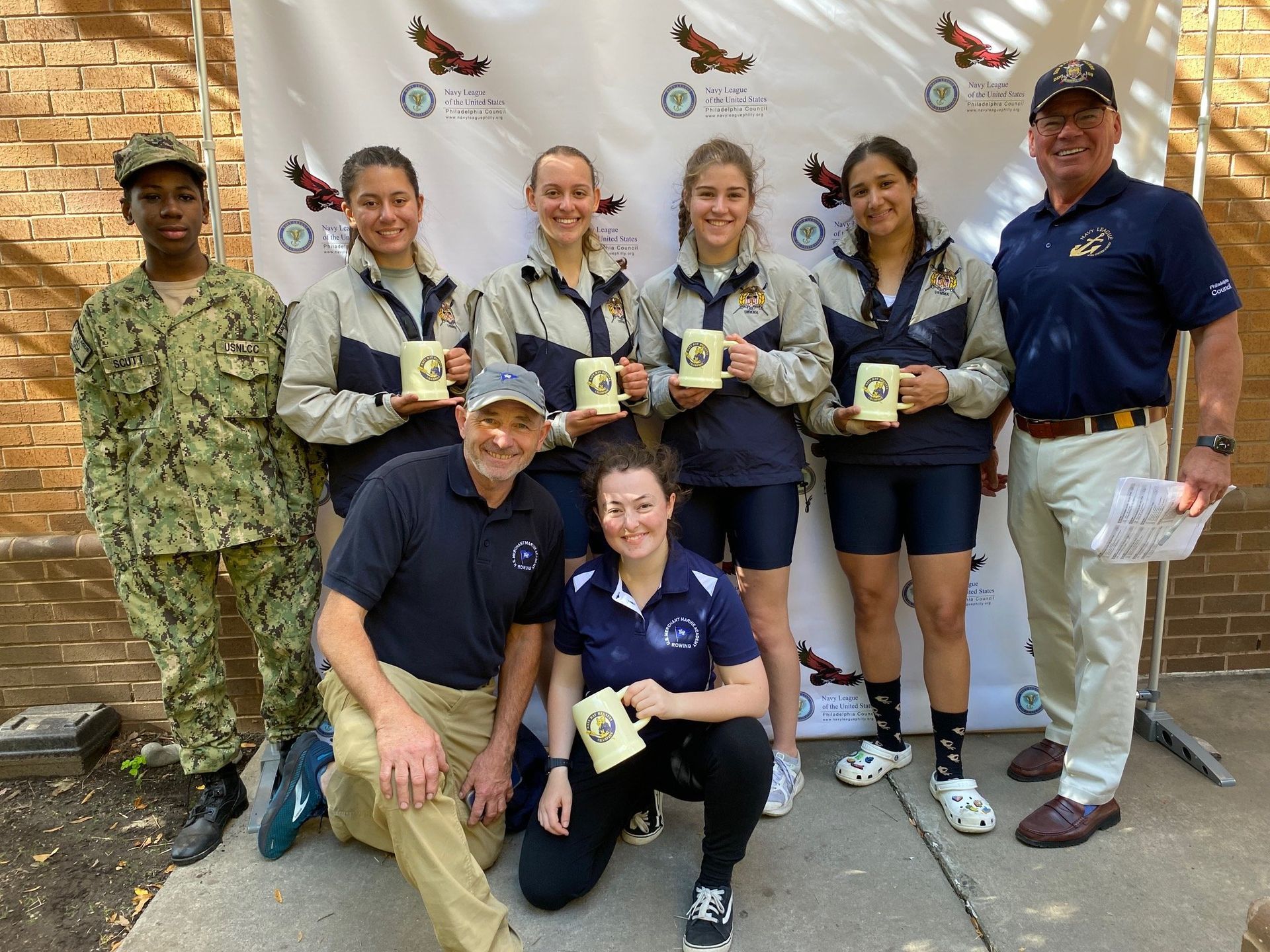 A group of people standing next to each other holding cups.