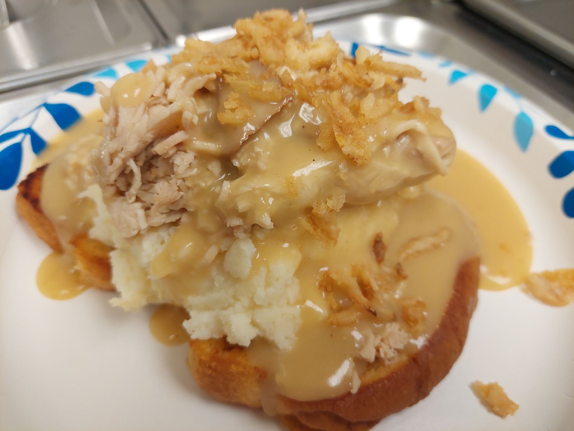 A plate of food with mashed potatoes and gravy on a table.