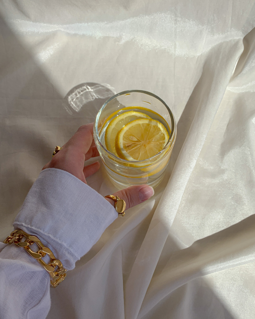 Glas Wasser mit Zitrone als Symbol für Hydration und natürlichen Haut-Glow