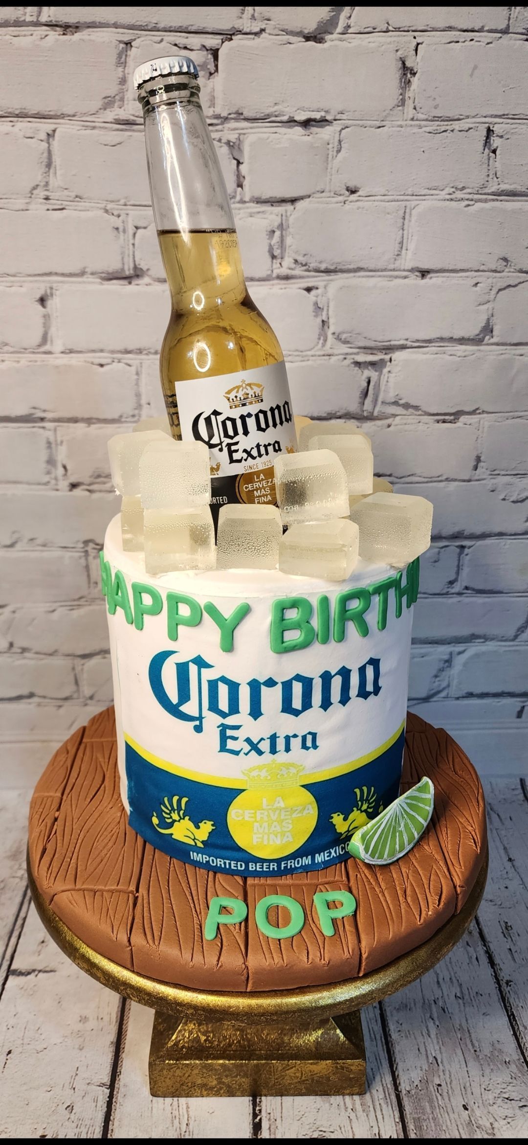 A birthday cake with a bottle of corona beer on top of it.