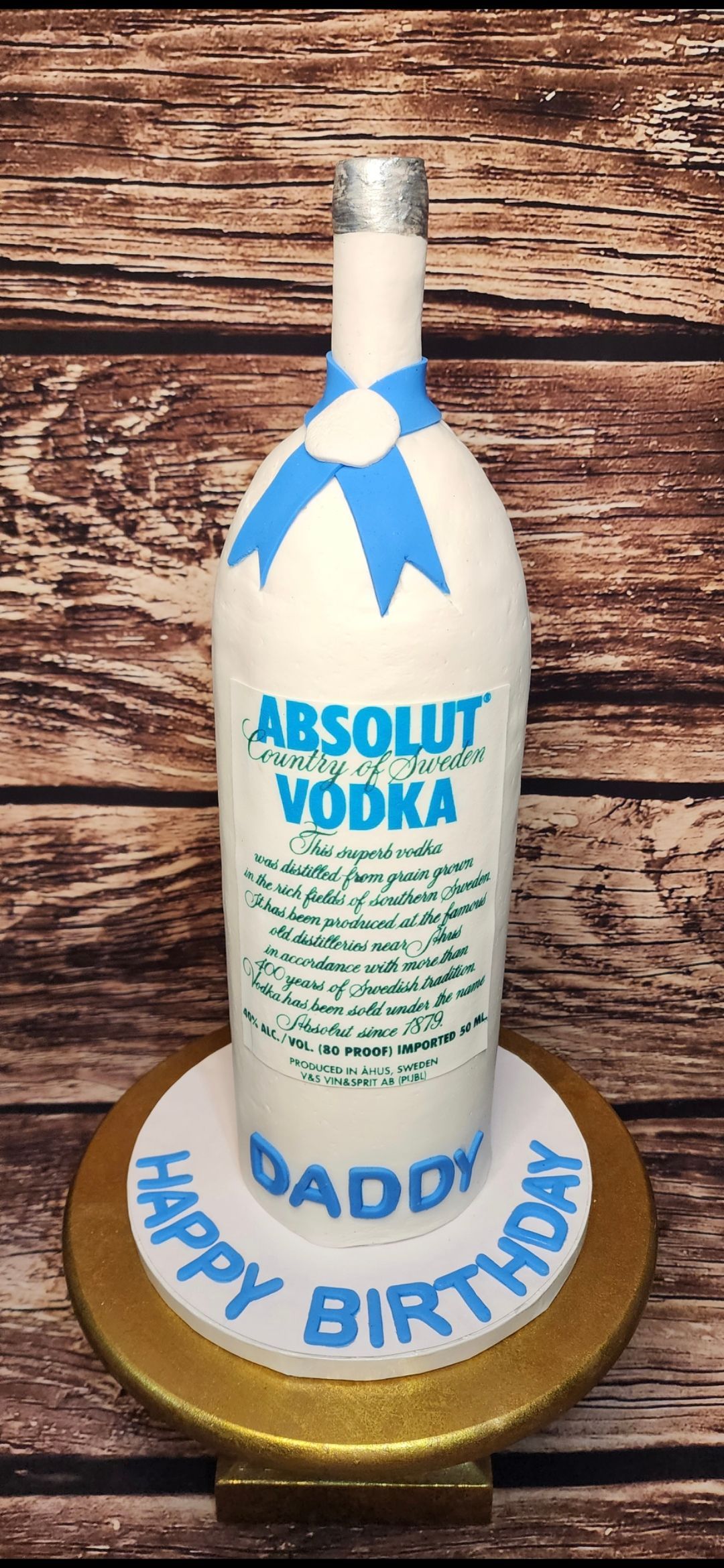 A cake in the shape of a bottle of absolut vodka.