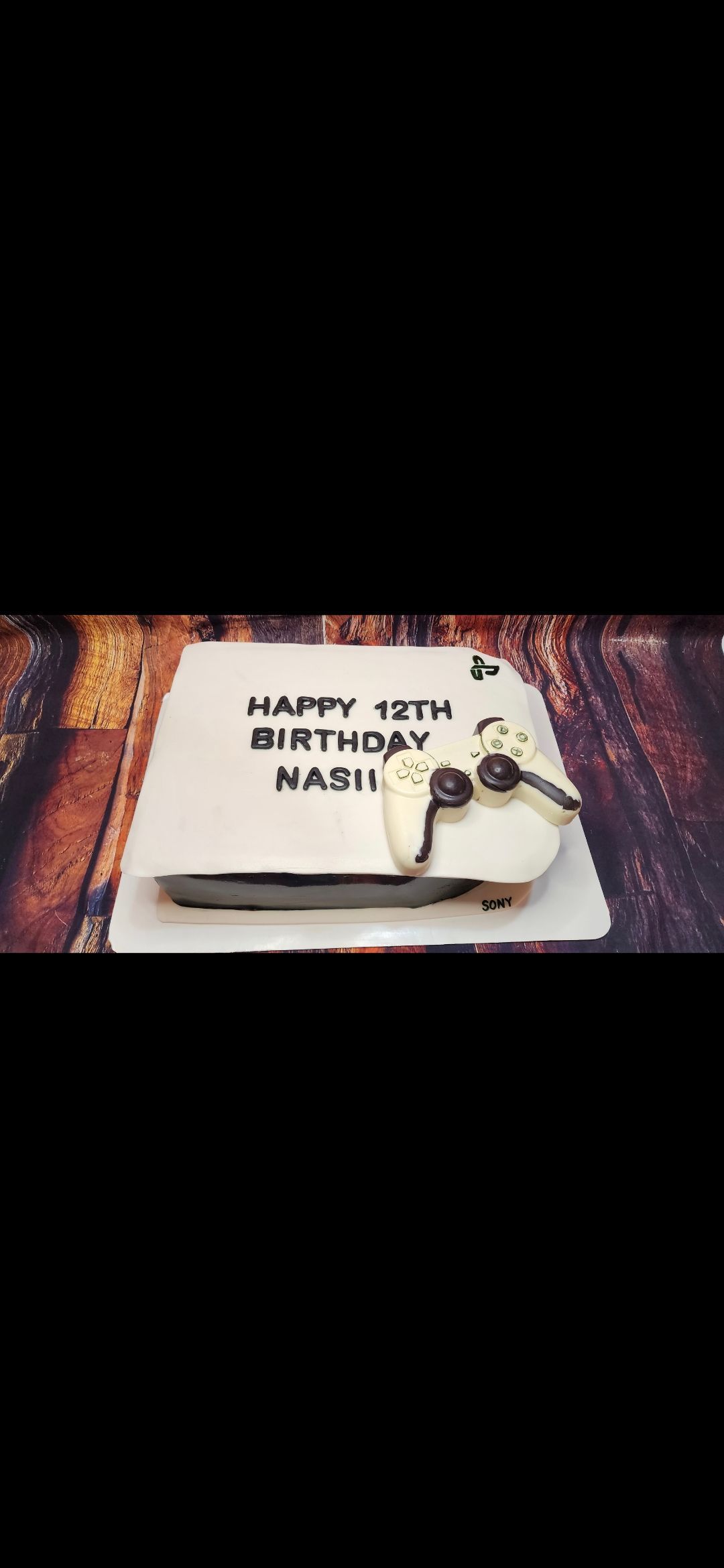 A birthday cake with a video game controller on it.