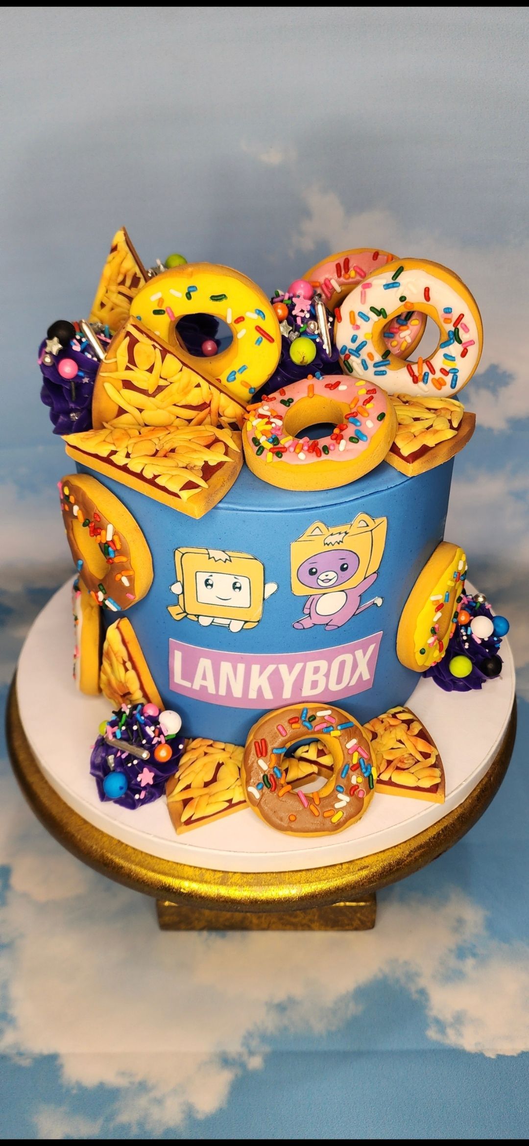 A blue cake with spongebob and donuts on it