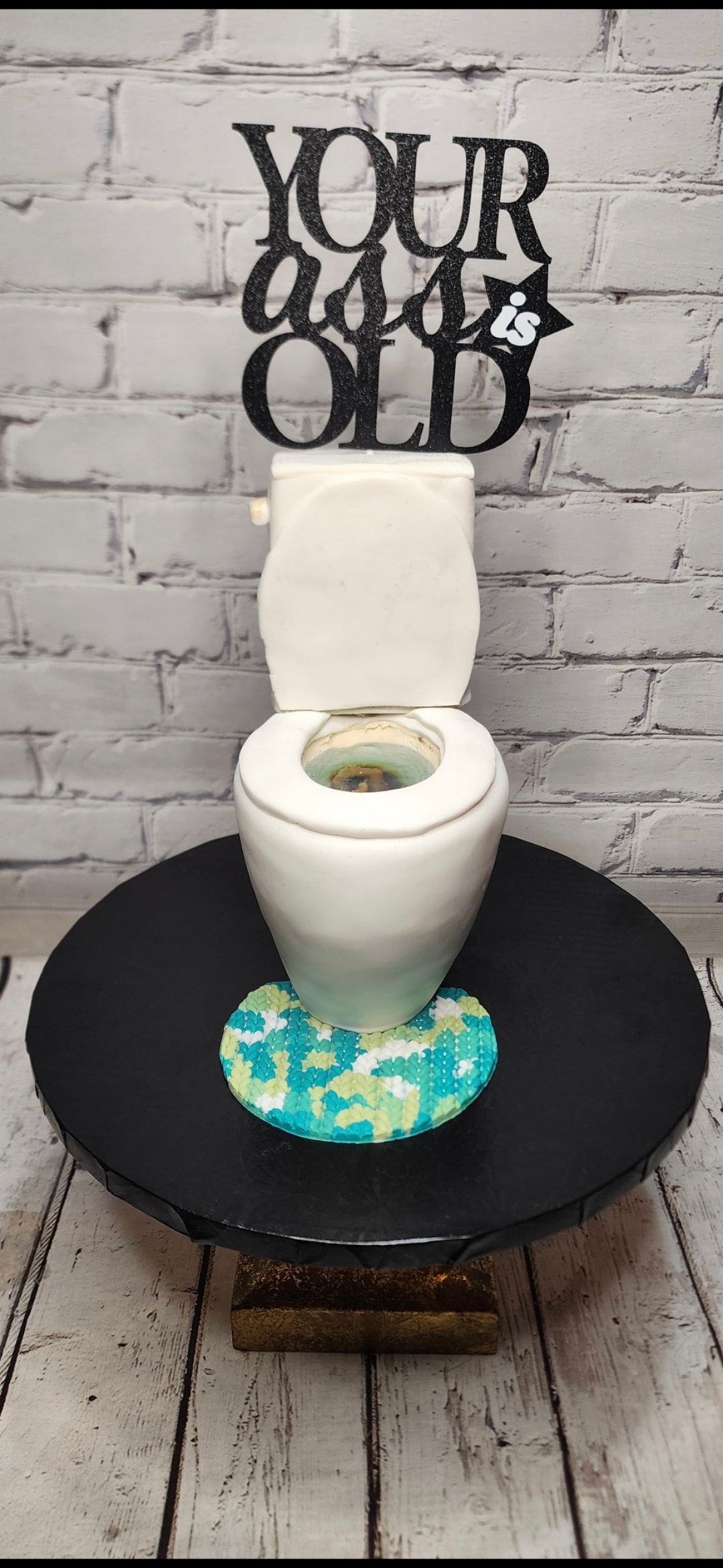 A toilet is sitting on top of a black plate.