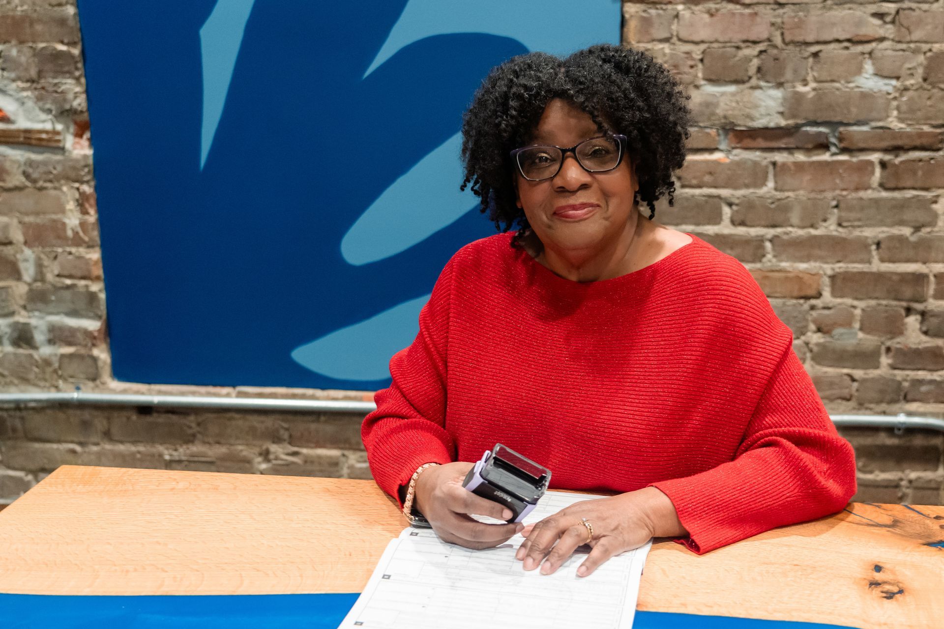 A man is giving keys to a woman who is signing a contract.
