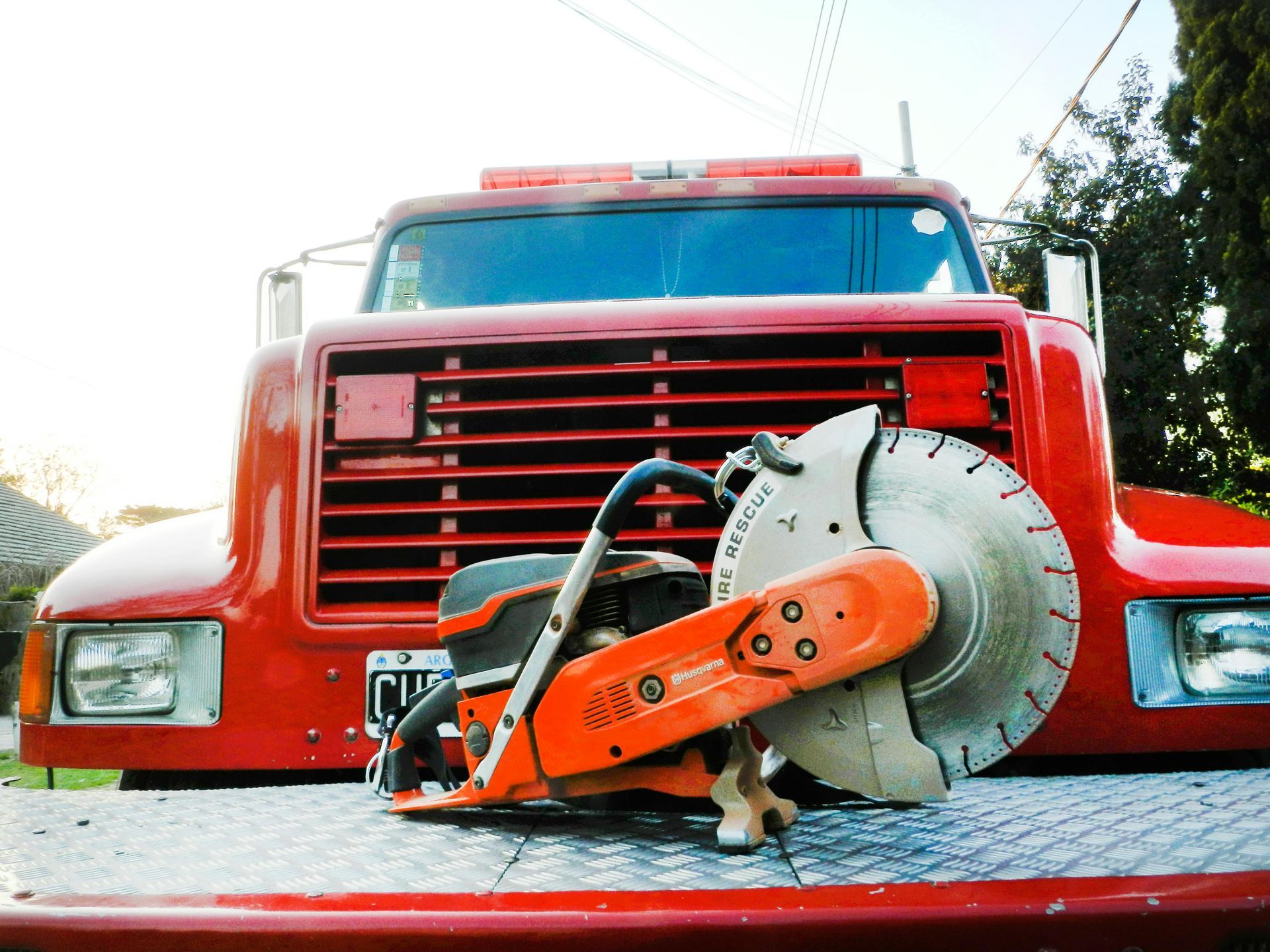 Red truck with a concrete saw on the front.