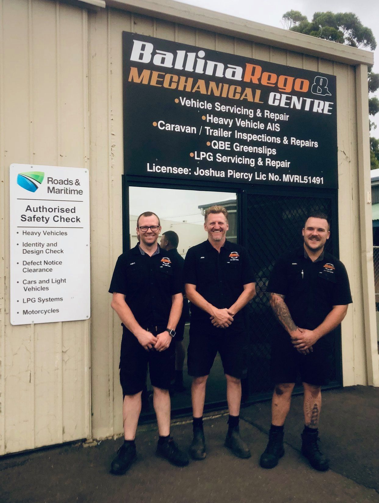 A Mechanic Is Holding A Tire In Front Of A Car — Ballina Rego & Mechanical Centre In Ballina, NSW