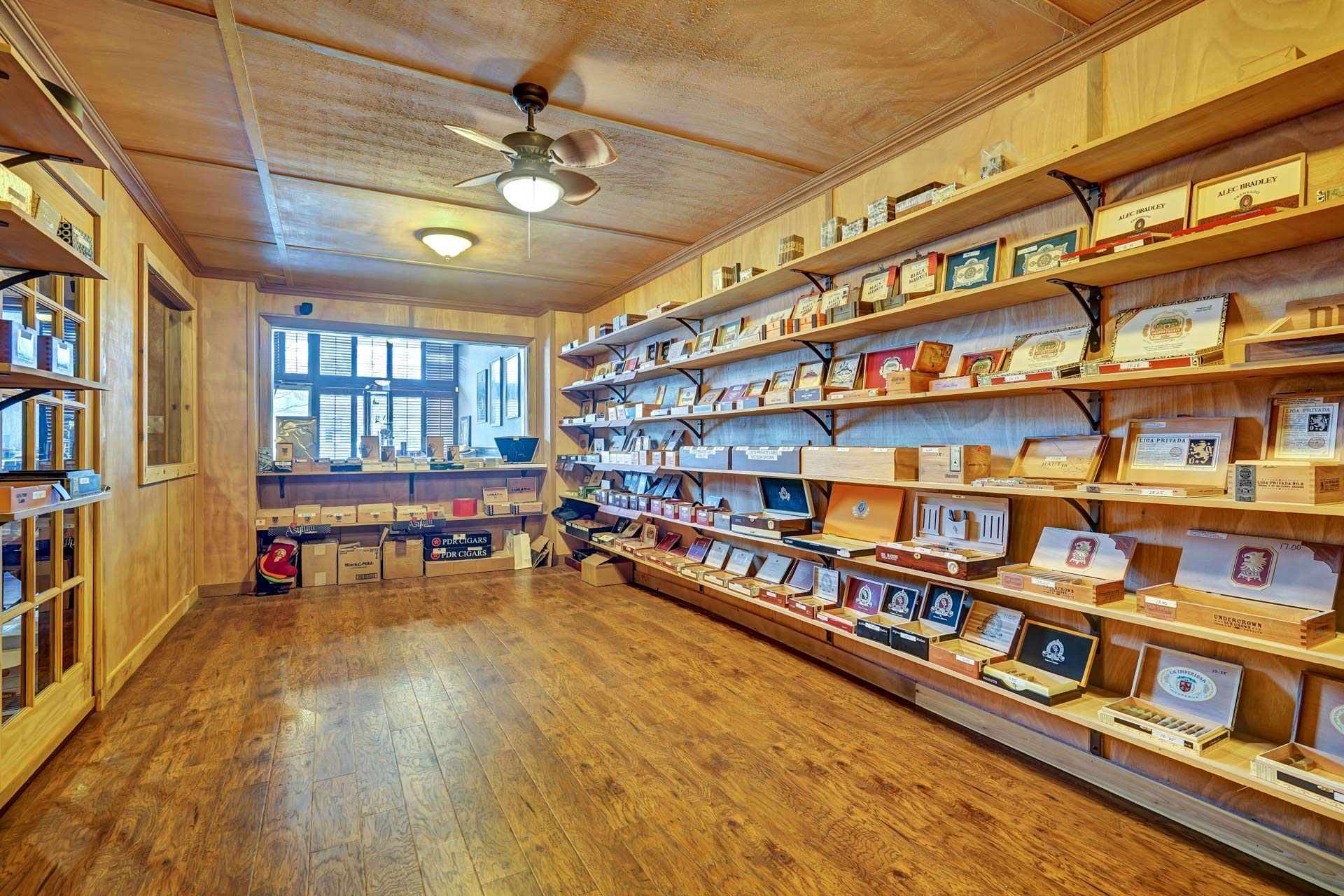 A room with a lot of shelves and a ceiling fan