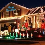 House decorated with colorful Christmas lights, illuminated reindeer, and candy cane figures at night