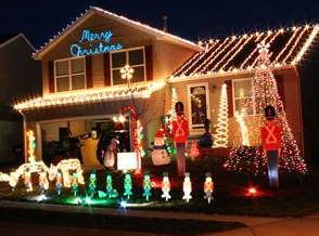 House decorated with colorful Christmas lights, glowing reindeer, and nutcracker figures at night