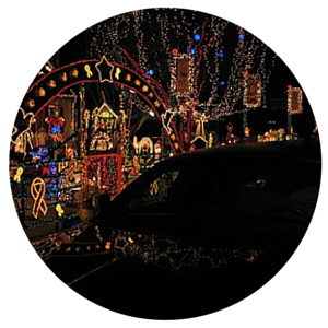 A car passes a house covered in colorful Christmas lights at night