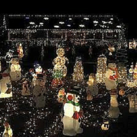 Nighttime yard filled with dozens of glowing holiday figures and string lights.